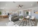 Bright, open-concept living room features a modern ceiling fan and flows seamlessly into the kitchen and dining area at 10829 W Woodruff Rd, Casa Grande, AZ 85194