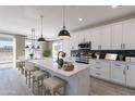 Modern kitchen with white cabinetry, a center island with seating, and stainless steel appliances at 10907 W Woodruff Rd, Casa Grande, AZ 85194