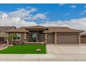Charming home featuring manicured landscaping, a three-car garage, and a welcoming entryway at 11055 E Ocaso Ave, Mesa, AZ 85212