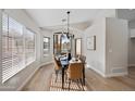 Dining room featuring a modern chandelier, large windows, and seating for six which is perfect for entertaining at 116 W Jasper Dr, Gilbert, AZ 85233