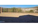 View of the backyard featuring an iron fence with a block wall and desert landscape beyond at 13250 W Eagle Feather Rd, Peoria, AZ 85383