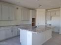 Bright kitchen with white cabinets, granite countertops, and an island, providing ample counter space at 13250 W Eagle Feather Rd, Peoria, AZ 85383