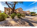 Beautiful home with a well-manicured front yard featuring decorative rock, lush bushes, and a large shade tree at 1344 N Constellation Way, Gilbert, AZ 85234