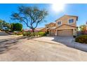 A spacious two-story home featuring a large shade tree, drought-resistant landscaping, and a wide driveway at 1344 N Constellation Way, Gilbert, AZ 85234