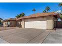 Spacious driveway leading to a two-car garage on a sunny day with clear blue skies at 1716 N Temple St, Mesa, AZ 85203