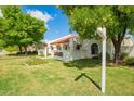 Beautiful single-story home showcasing a red tile roof, white stucco exterior, and mature trees on a well-manicured lawn at 1934 E Hale St, Mesa, AZ 85203