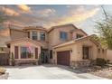 Attractive two-story home with desert landscaping, a cozy porch, and a convenient two-car garage at 21557 N Anne Ln, Maricopa, AZ 85138