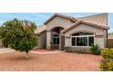Well-maintained single-story home featuring large windows and desert landscaping in the front yard at 2319 E San Tan Dr, Gilbert, AZ 85296