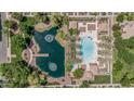 Aerial view of community pool, playground, and pond with fountain and dock at 2658 S Sulley Dr # 102, Gilbert, AZ 85295