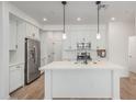 Modern kitchen with white cabinets, stainless steel appliances, and a large center island with sink at 2658 S Sulley Dr # 102, Gilbert, AZ 85295