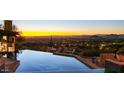 Sunset view from the infinity pool overlooking the city and mountains, creating a serene oasis at 26796 N 98Th Way, Scottsdale, AZ 85262