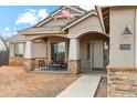 Inviting front porch features a cozy seating area, stone accents, and a well-defined walkway to the entrance at 27420 N 170Th St, Rio Verde, AZ 85263