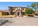 Exterior of home featuring stone accents, arched entry, and a paved driveway leading to a grand entrance at 3312 N 89Th Pl, Mesa, AZ 85207