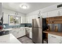 Bright kitchen with stainless appliances, white cabinets, subway tile backsplash, and breakfast bar at 5422 E Des Moines St, Mesa, AZ 85205