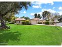 Single-story home boasting lush green grass and mature landscaping with a two-car garage at 5465 N 78Th St, Scottsdale, AZ 85250