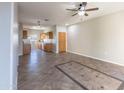 Inviting living room with tile flooring, ceiling fan, and open access to the kitchen area at 6538 W Elwood St, Phoenix, AZ 85043