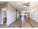 Spacious open-concept living room features tile flooring, ceiling fan, and access to the kitchen at 6538 W Elwood St, Phoenix, AZ 85043
