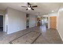 Bright, open-concept living space with tile flooring and ceiling fan seamlessly connects to the kitchen at 6538 W Elwood St, Phoenix, AZ 85043