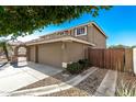 Side view of house with garage and gated walkway showing driveway and landscaping at 7164 W Paso Trl, Peoria, AZ 85383