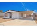 Charming single-story home featuring a gravel front yard, carport, and black and white trim at 7707 E Garnet Ave, Mesa, AZ 85209