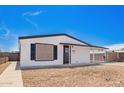 Charming single-story home featuring a gravel front yard, carport, and black and white trim at 7707 E Garnet Ave, Mesa, AZ 85209