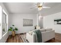 Bright living room with hardwood floors, white walls, modern decor, and a ceiling fan at 7707 E Garnet Ave, Mesa, AZ 85209