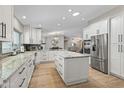 Open concept kitchen with white cabinets, granite countertops, and stainless steel appliances at 12411 N 57Th St, Scottsdale, AZ 85254