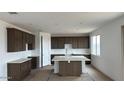 Contemporary kitchen featuring a center island, dark wood cabinetry, and modern countertops at 15146 W Gray Fox Trl, Surprise, AZ 85387