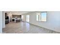 Open-concept living space with wood-look tile flooring, big windows, and sliding glass doors to the backyard at 15146 W Gray Fox Trl, Surprise, AZ 85387