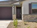 Elegant front door with stone accents and a well-manicured yard, leading to a welcoming entrance at 16015 W Desert Hollow Dr, Surprise, AZ 85387