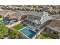 Aerial view of the home showcasing its backyard oasis with a pool, spa, covered patio, and artificial turf at 10792 W Whitehorn Way, Peoria, AZ 85383