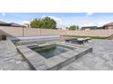 This backyard pool and spa feature a clean modern design and plenty of space for entertaining at 10792 W Whitehorn Way, Peoria, AZ 85383