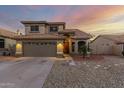 Exterior view of a two-story home with a tile roof, a two-car garage, and desert landscaping at 10866 S Dreamy Dr, Goodyear, AZ 85338