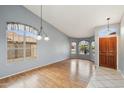 Bright, open living room features wood floors, neutral paint, and large windows with decorative valances at 10866 S Dreamy Dr, Goodyear, AZ 85338