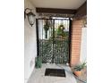 Welcoming gated entry with decorative plants, a black gate and overhead lamp at 12221 S Paiute St, Phoenix, AZ 85044