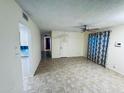 A spacious living room with tile floors, a ceiling fan, and a view into other rooms at 12221 S Paiute St, Phoenix, AZ 85044