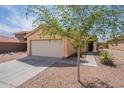 Single-story home with a well-kept front yard, featuring desert landscaping and a driveway leading to a two-car garage at 168 S 223Rd Dr, Buckeye, AZ 85326