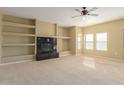 Spacious living room with a fireplace, built-in shelving, and neutral carpet throughout at 20121 N 76Th St # 2064, Scottsdale, AZ 85255