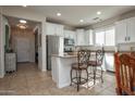 Bright kitchen boasts stainless steel appliances, white cabinets, granite counters, and an eat-in island at 20222 N 267Th Ln, Buckeye, AZ 85396