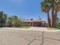 Street view of home featuring a car port, desert landscaping, and two large palm trees at 2049 W Joan De Arc Ave, Phoenix, AZ 85029