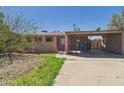 View of a house featuring a carport and desert landscaping with gravel and sparse grass at 2049 W Joan De Arc Ave, Phoenix, AZ 85029