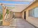 Exterior of house showcasing a patio area with trellis covering, concrete floors, and neutral stucco walls at 2049 W Joan De Arc Ave, Phoenix, AZ 85029