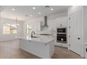 Bright, open kitchen with white cabinetry, stainless steel appliances, and a large center island at 21846 E Bonanza Ct, Queen Creek, AZ 85142