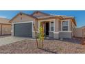 Charming single-story home featuring a gray garage door and low-maintenance desert landscaping at 25314 N 133Rd Ave, Peoria, AZ 85383