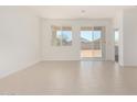 Bright, airy living room with neutral tile flooring and sliding glass door access at 25314 N 133Rd Ave, Peoria, AZ 85383