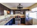Charming kitchen featuring stainless steel appliances, dark wood cabinets, and granite countertops at 2605 W Rose Ln # B-202, Phoenix, AZ 85017