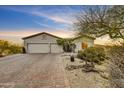 Single-story home featuring desert landscaping and a three-car garage at 32806 N 55Th Pl, Cave Creek, AZ 85331