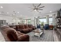 Spacious living room area featuring a large comfortable couch, ceiling fan, and an open floor plan at 3522 E Penedes Dr, Gilbert, AZ 85298