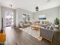 Bright and airy living room with modern furnishings, neutral decor, and wood-look tile flooring at 4171 E Ronald St, Gilbert, AZ 85295