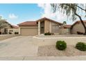 Single-story home showcasing desert landscaping, a tile roof, and a spacious two-car garage at 4436 E Shomi St, Phoenix, AZ 85044